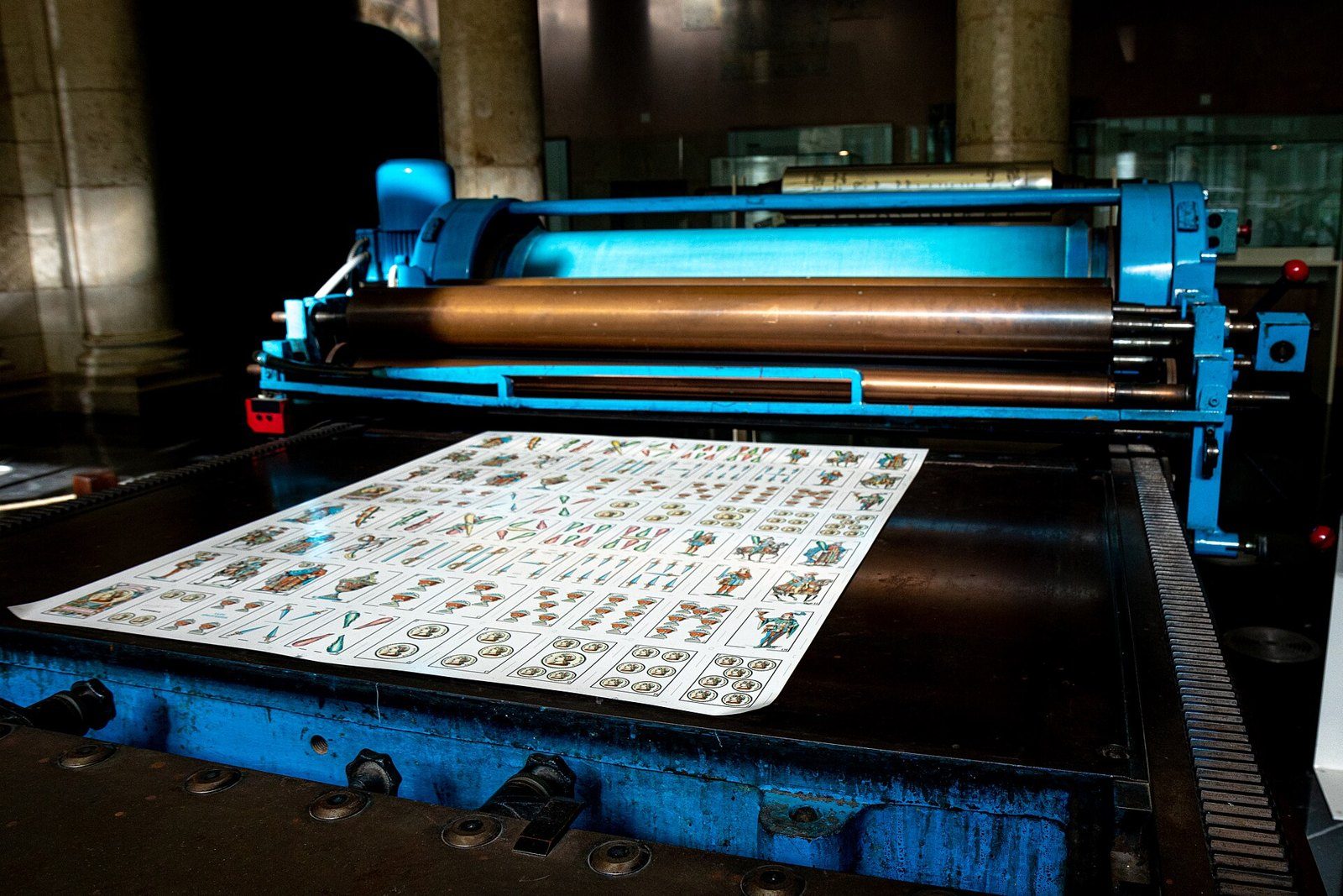 Pliego de naipes españoles impreso sobre la plancha de una antigua prensa azul de imprenta en el museo de naipes de Vitoria